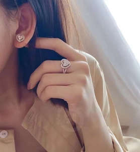 Elegant silver heart-shaped jewelry set with rings and earrings on female model