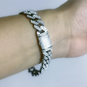 Close-up of a silver hip-hop Cuban link bracelet with iced-out rhinestones on a wrist