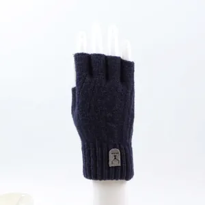 Detail of dark blue knitted fingerless gloves with ribbed cuffs and reindeer patch