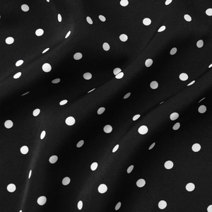 Detail view of the black and white polka dot fabric texture on the summer dress