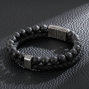 Macro shot of double-layer men's bracelet with black lava stone and braided leather strap