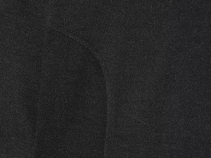 Detailed close-up of soft black knit fabric texture with curved stitching for women dress