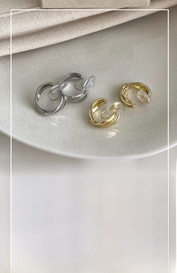 Vue détaillée de boucles d'oreilles clips rondes croisées de 2cm en or et argent
