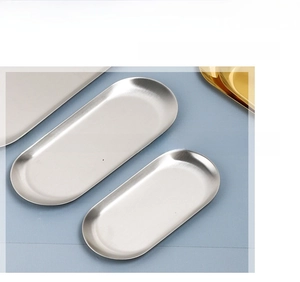 Detail of brushed stainless steel rectangular trays in gold and silver finishes