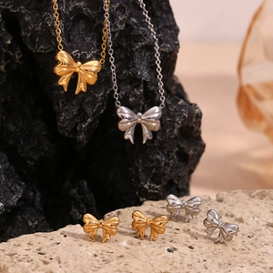Exquisite 18K gold and silver ribbon bow necklace and earrings set on natural rock stones