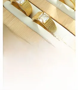 Vue détaillée de bagues dorées avec zircone carrée et textures gravées verticalement