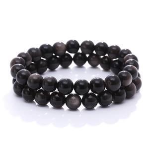 Natural black obsidian bead bracelets with cat eye effect on a white background