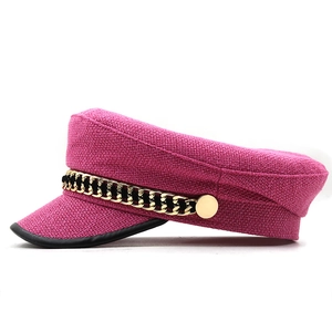 Detail of tweed newsboy cap with gold chain decoration and black leather brim trim