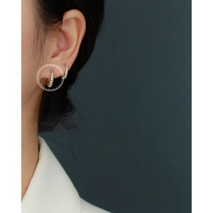Macro shot of silver twisted rope hoop earring worn on ear with high metallic luster