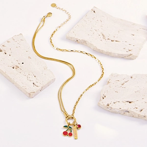 Golden double layer necklace with cherry pendant and AMOUR tag on white stone