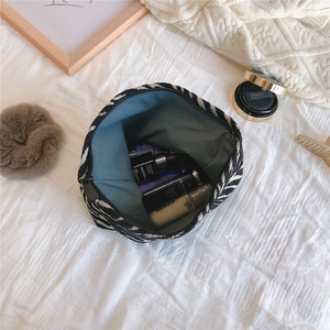 Detail view of large zebra stripe canvas pouch showing green lining and cosmetics storage