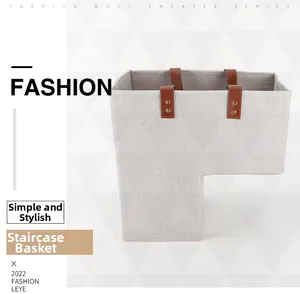 Detailed view of grey fabric L-shaped stair basket with sturdy leather handles and rivets