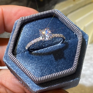 Classic round cut zircon engagement ring with pave stones in a velvet hexagon box