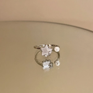 Detailed macro view of an adjustable star ring with white pearl and sparkling crystals