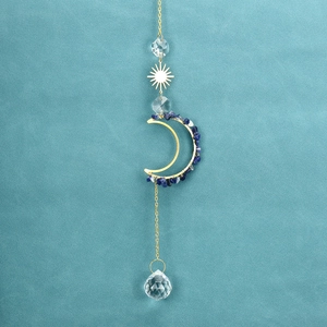 Close-up of golden moon and sun suncatcher with blue stones and clear crystal prism