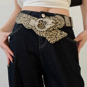 Detail of leopard print wide belt with sparkling rhinestone buckle and butterfly charm
