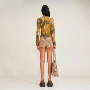 Vue arrière d'une femme portant un haut en maille camouflage et un short en jean usé