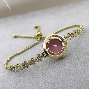 Detail of red dial ladies watch with floral rhinestone gold bracelet and sliding buckle