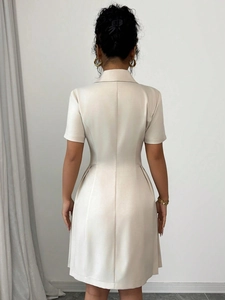 Achteraanzicht van crèmekleurige jurk met getailleerde taille en naden op de rug