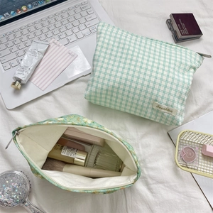 Detail of floral and plaid makeup bags with interior view showing beauty products