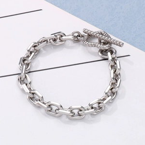 Macro shot of silver chain bracelet featuring rectangular links and twisted T-bar clasp