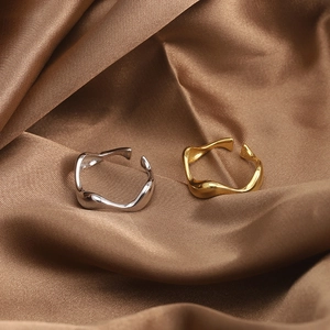 Macro shot of polished S925 sterling silver and gold minimalist wave open rings