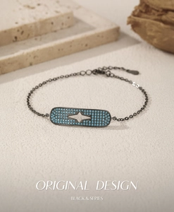Macro detail of black hip-hop bracelet with blue turquoise pave and starburst center