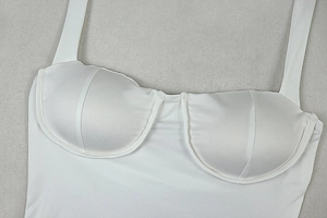Close-up of white halter dress featuring underwire cups and ribbed fabric texture