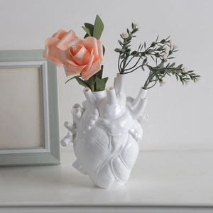 Artistic white anatomical heart ceramic vase with realistic vein texture and pink roses
