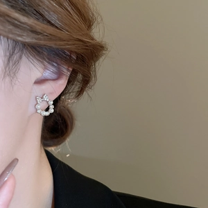 Close-up of elegant bow pearl wreath earrings worn on ear showing fine zircon details