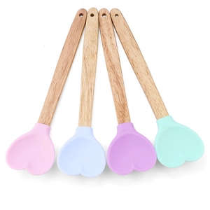 Close-up of four heart-shaped silicone spoons with bamboo handles in macaron colors