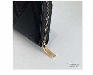 Detail of golden zipper teeth and precision stitching on the black PU leather wallet