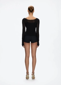Rear view of black low-waist slim shorts and sheer long-sleeve top on model