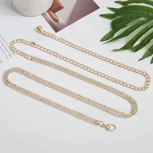 Detail of elegant gold waist chain with rhinestones and lobster clasp, 115cm length
