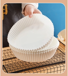 Macro shot of stacking round white parchment paper liners with pleated edges on a metal rack