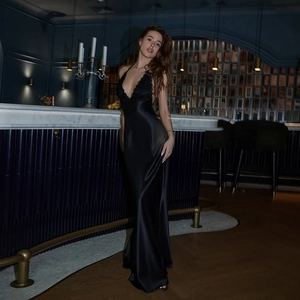 Détail d'une robe longue en satin noir élégante avec décolleté en V profond et dentelle