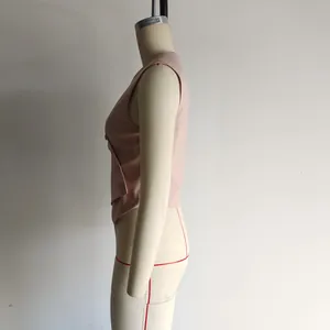 Detail view of pink asymmetrical vest with side buttons and irregular fishtail hemline