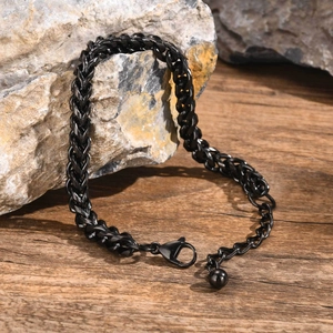 Close-up of black braided dragon bone link chain bracelet with lobster clasp and ball charm