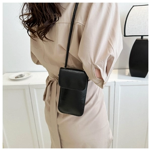Minimalist black leather phone crossbody bag shown on model for size and style reference