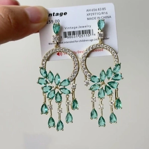 Detailed shot of vintage gold earrings with teal marquise stones and crystal tassels