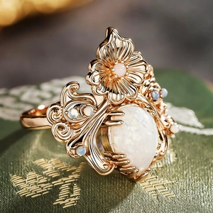 Vue macro d'une bague fleur en or vintage avec une grande opale ovale et des perles
