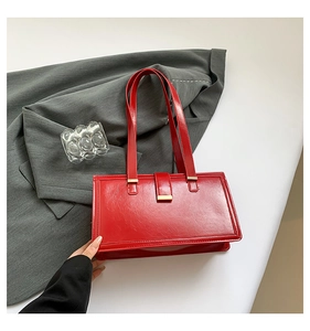 Nahaufnahme der roten rechteckigen Leder-Schultertasche mit goldener Metallschnalle