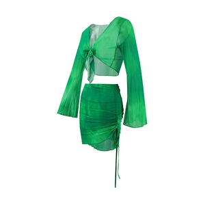 Detail of green tie-dye mesh set featuring bell sleeves and side drawstring skirt