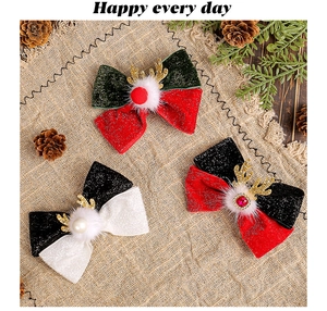 Flat lay of festive Christmas bow hair clips with reindeer antlers and fur balls on burlap
