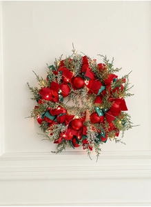 Close-up of a 40cm Christmas wreath with red berries, silk ribbons, and warm LED lights