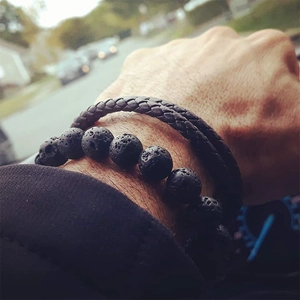 Detail of men's black volcanic lava stone beads and braided leather bracelet set