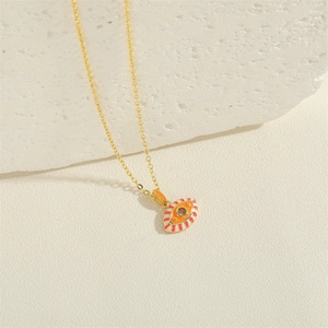 Macro detail of gold evil eye pendant with vibrant enamel rays and zircon stone