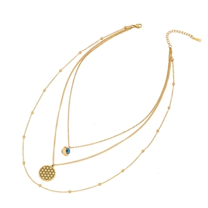 Gold stainless steel layered necklace with evil eye and geometric charms on white background