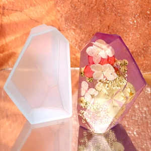 Macro detail of geometric faceted crystal silicone mold with dried flower resin finished piece