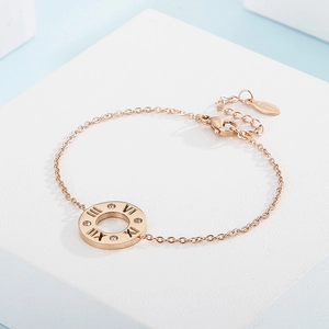 Macro shot of rose gold stainless steel bracelet featuring roman numerals and zircons